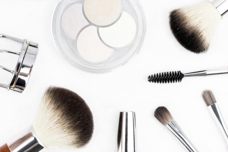 Make-up brushes and compacts laid out on a white surface